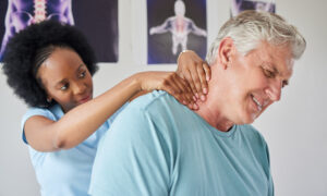 woman chiropractor with a patient in her office - Chiropractic Adjustment